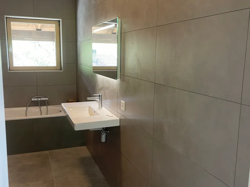 Salle de bains terminée avec baignoire et carrelage pierre naturelle